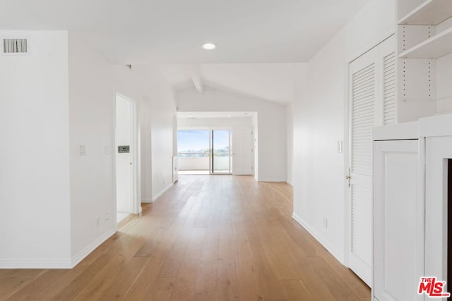 hallway with light hardwood / wood-style floors and lofted ceiling with beams