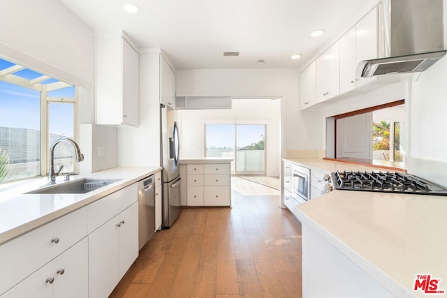 kitchen with sink, extractor fan, white cabinetry, and appliances with stainless steel finishes