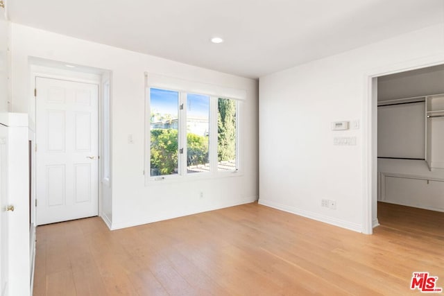 unfurnished bedroom with a closet and light hardwood / wood-style floors