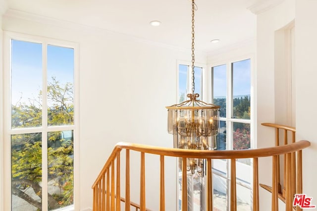 corridor featuring a notable chandelier and crown molding