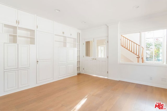 interior space featuring built in features, crown molding, and light wood-type flooring