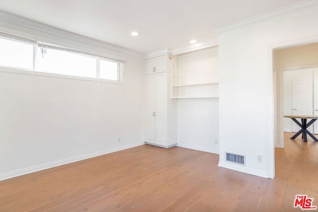 spare room with crown molding and light hardwood / wood-style floors