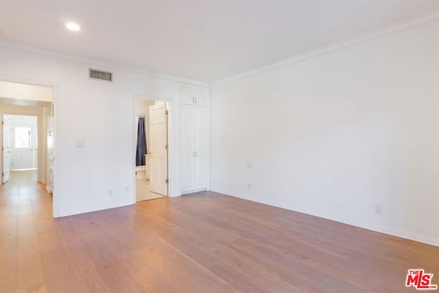 spare room featuring light hardwood / wood-style flooring and ornamental molding