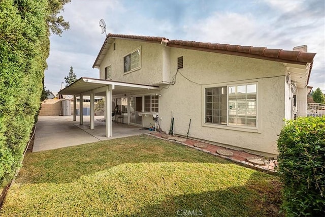 rear view of house with a yard and a patio area