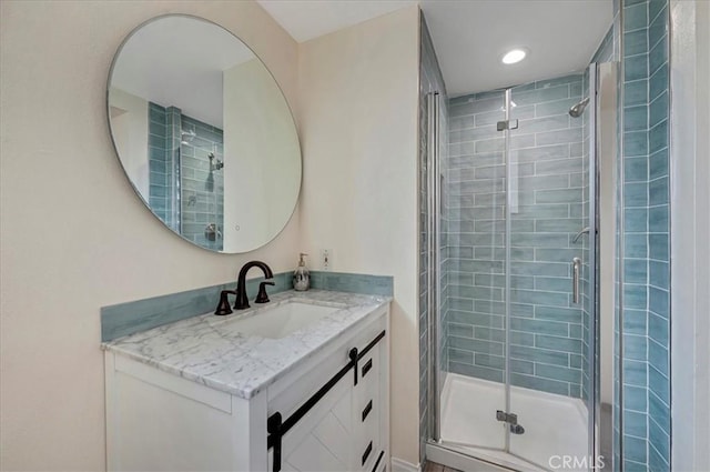 bathroom featuring vanity and a shower with door