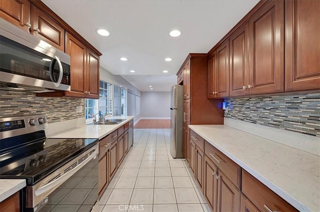 kitchen with sink, light tile patterned floors, stainless steel appliances, and tasteful backsplash