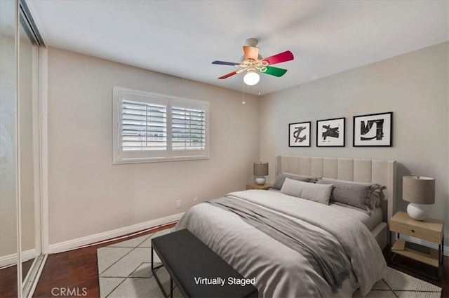 bedroom featuring ceiling fan, dark hardwood / wood-style floors, and a closet