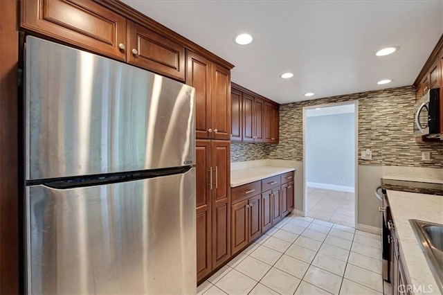 kitchen featuring decorative backsplash, light tile patterned floors, and appliances with stainless steel finishes