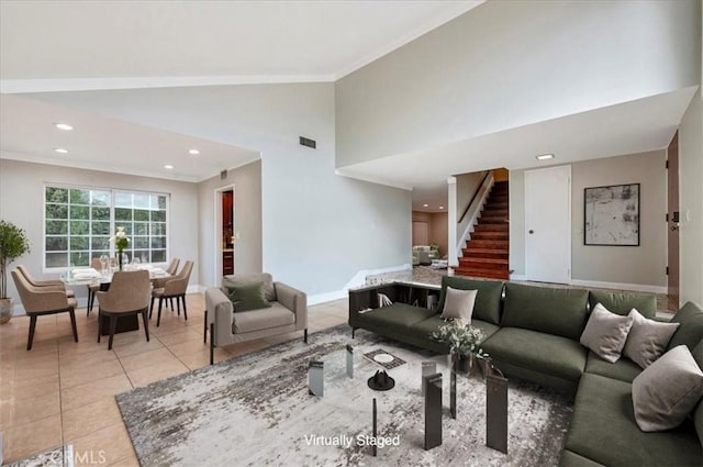 tiled living room featuring ornamental molding and high vaulted ceiling