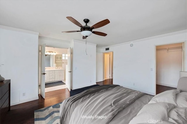 bedroom featuring dark wood-type flooring, ceiling fan, a spacious closet, connected bathroom, and a closet