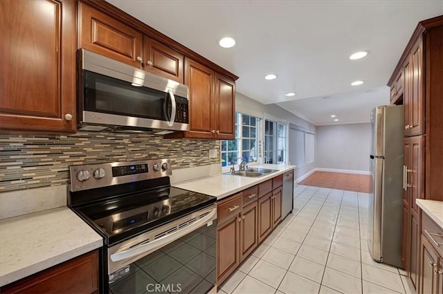 kitchen with decorative backsplash, stainless steel appliances, vaulted ceiling, sink, and light tile patterned floors