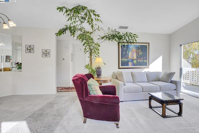 carpeted living room featuring a chandelier