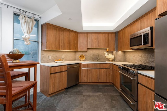 kitchen with appliances with stainless steel finishes, backsplash, and sink