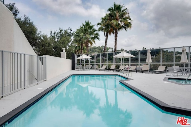 view of pool featuring a patio area and a hot tub