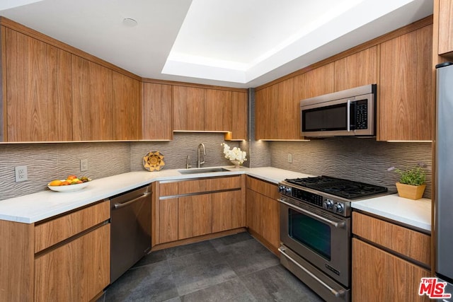 kitchen featuring a raised ceiling, decorative backsplash, sink, and stainless steel appliances