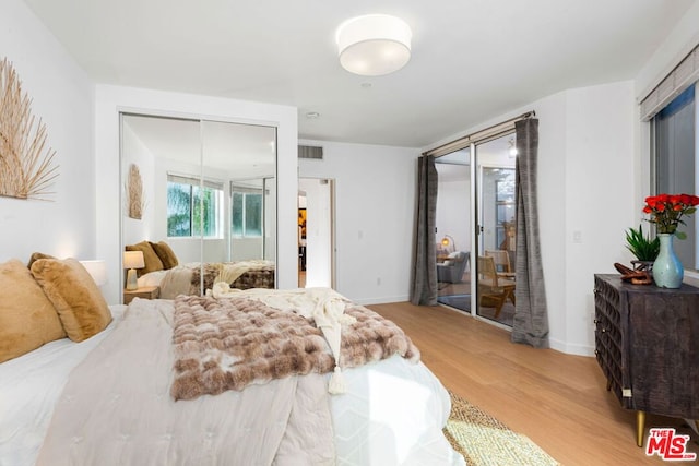 bedroom featuring access to exterior and hardwood / wood-style floors