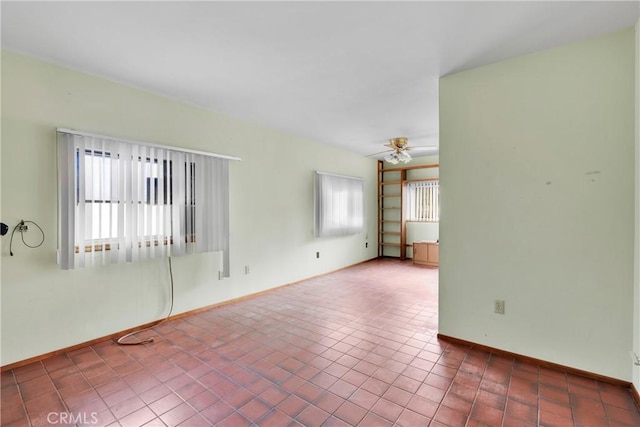 spare room featuring tile patterned floors and ceiling fan