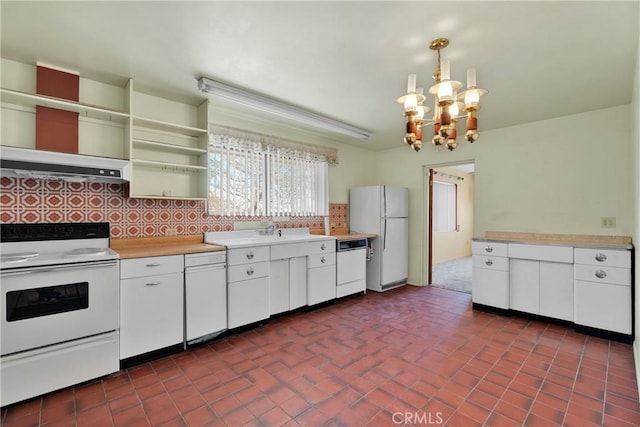 kitchen with decorative backsplash, white appliances, white cabinets, a chandelier, and hanging light fixtures