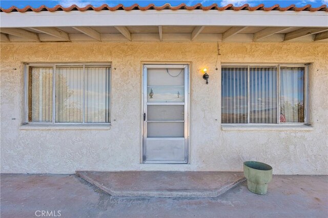 32222 Richard St, Lucerne Valley, CA 92356 - view of exterior entry with a tiled roof and stucco siding