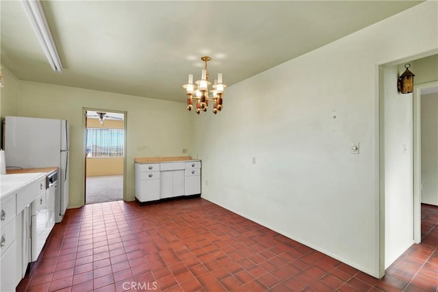 kitchen with an inviting chandelier, white cabinetry, and dark tile patterned floors