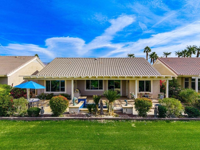 rear view of property with a yard and a patio