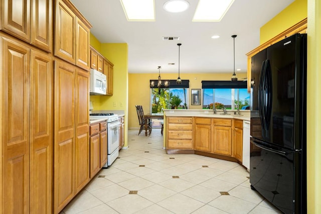 kitchen featuring light tile patterned flooring, sink, hanging light fixtures, and white appliances