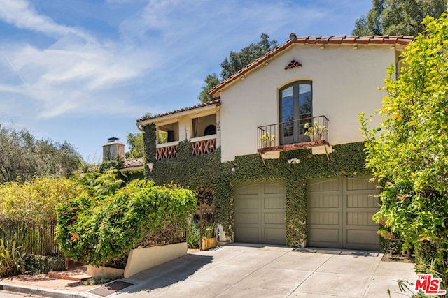 mediterranean / spanish home with a garage and a balcony