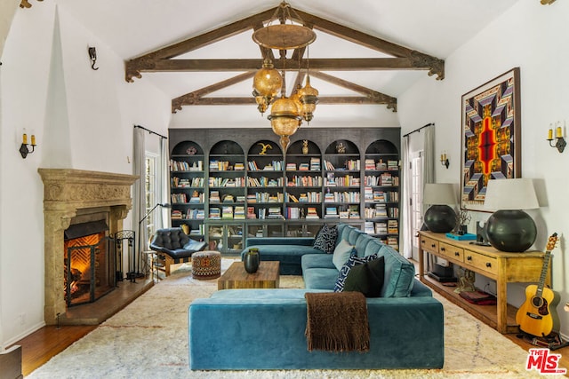 living room featuring beam ceiling, high vaulted ceiling, hardwood / wood-style flooring, and an inviting chandelier