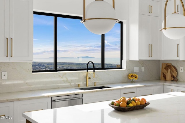 kitchen with tasteful backsplash, white cabinetry, plenty of natural light, and sink