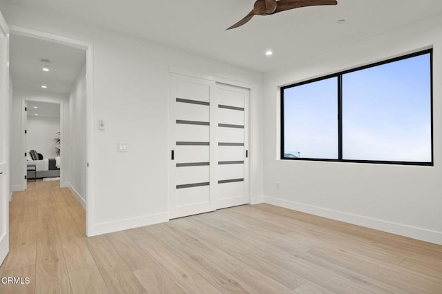 unfurnished bedroom with ceiling fan, a closet, and light hardwood / wood-style flooring