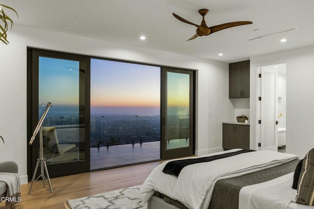 bedroom with access to outside, light hardwood / wood-style flooring, ceiling fan, and ensuite bathroom