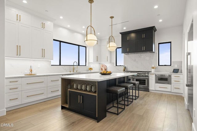 kitchen with white cabinets, light wood-type flooring, and a kitchen island