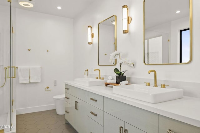 bathroom featuring tile patterned flooring, vanity, toilet, and an enclosed shower