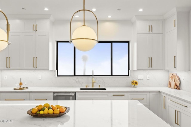 kitchen featuring white cabinets, pendant lighting, stainless steel dishwasher, and a healthy amount of sunlight