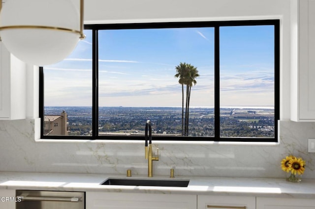 kitchen with backsplash, dishwasher, white cabinetry, and sink