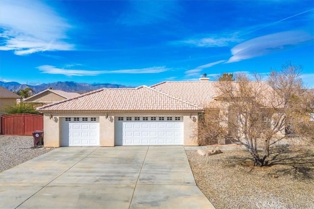 8550 Condalia Ave, Yucca Valley, CA 92284 - ranch-style house with stucco siding, driveway, a garage, a tiled roof, and a mountain view