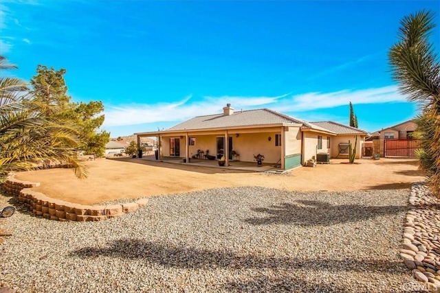 8550 Condalia Ave, Yucca Valley, CA 92284 - rear view of house with a patio, stucco siding, and a chimney