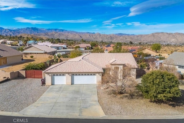 8550 Condalia Ave, Yucca Valley, CA 92284 - view of front facade with a tiled roof, a garage, driveway, stucco siding, and a residential view