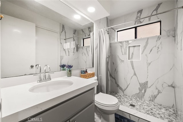 full bath featuring vanity, a marble finish shower, toilet, and recessed lighting