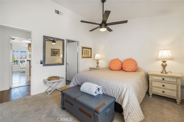 carpeted bedroom with visible vents, ceiling fan, and a towering ceiling