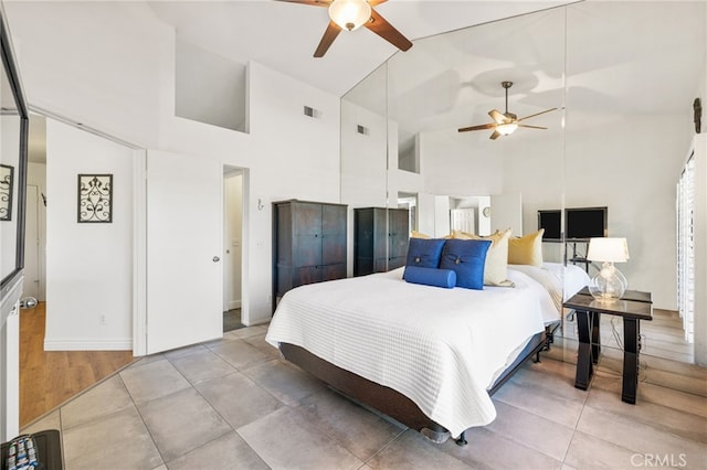 bedroom featuring high vaulted ceiling, visible vents, and tile patterned floors