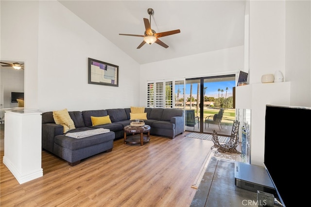 living area featuring light wood-style floors, ceiling fan, and high vaulted ceiling