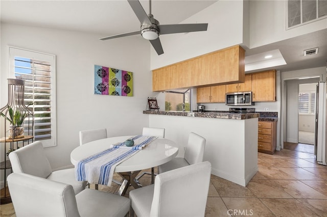 dining room with light tile patterned flooring, plenty of natural light, visible vents, and a ceiling fan