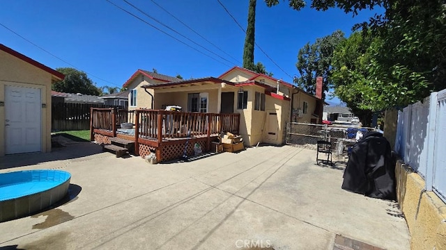 rear view of property with a patio area and a wooden deck