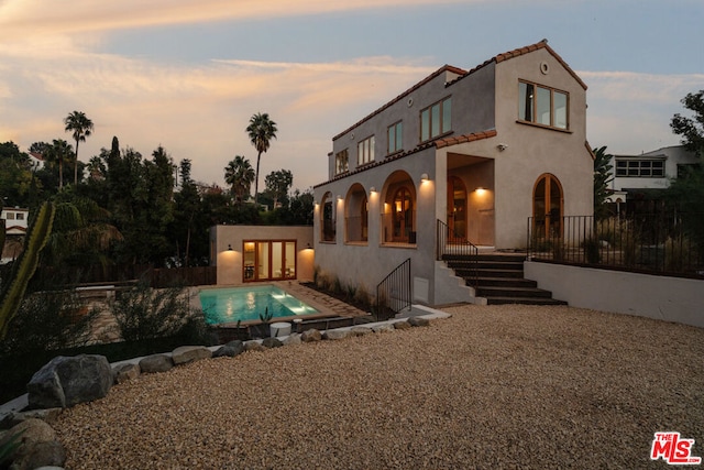 view of front of house with a balcony and a patio area