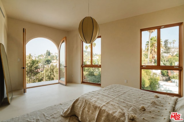 bedroom featuring access to outside and concrete floors