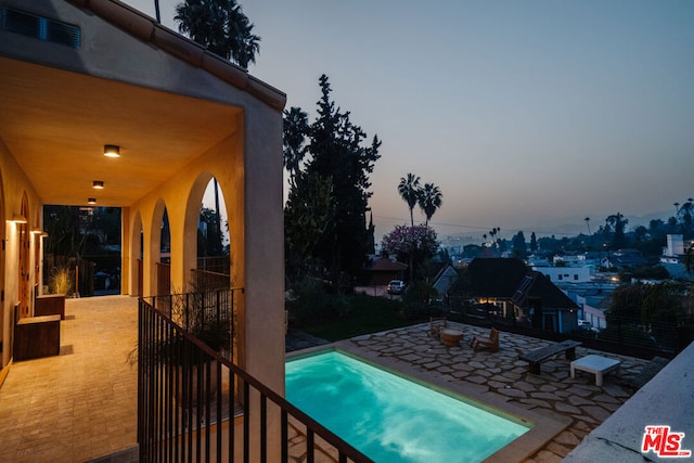 pool at dusk with a patio