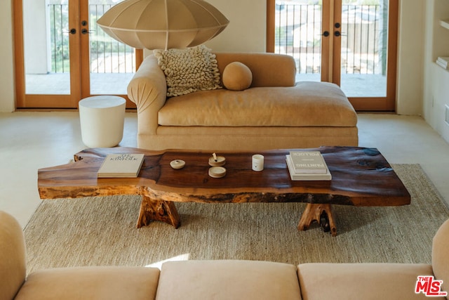 living room featuring french doors and concrete flooring