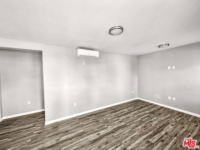 basement with dark hardwood / wood-style floors and a wall mounted air conditioner