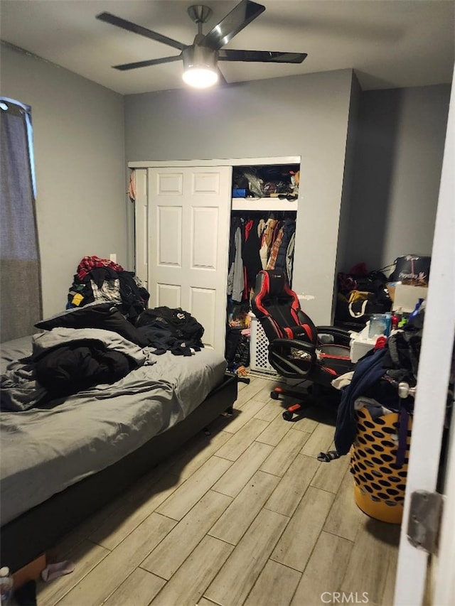 bedroom featuring hardwood / wood-style floors, ceiling fan, and a closet